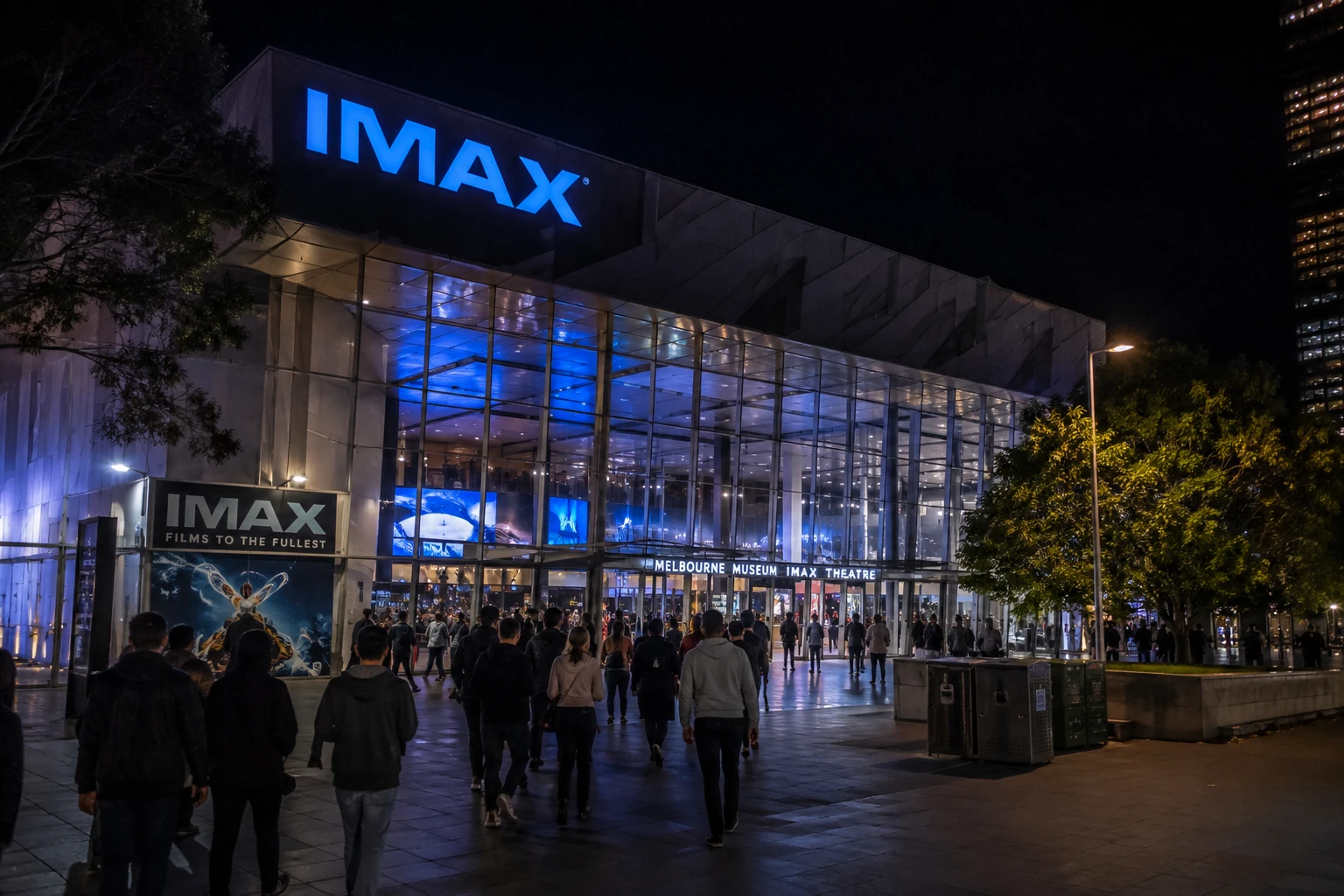 نمای شبانه ورودی شیشه‌ای سینمای آی‌مکس موزه ملبورن با تابلوی نورانی IMAX و جمعیت تماشاگران در حال ورود
